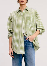 Load image into Gallery viewer, Person wearing a green and white checkered shirt with rolled-up sleeves and blue jeans on a light gray background