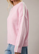Load image into Gallery viewer, Pink sweater with white stripes on sleeves worn by a person against a plain background