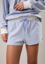Load image into Gallery viewer, Person wearing a light blue striped outfit with shorts and a top on a neutral background