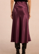 Load image into Gallery viewer, Person wearing a burgundy satin skirt on a beige background