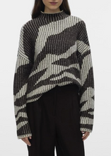 Load image into Gallery viewer, Person wearing a black and white patterned sweater on a plain background