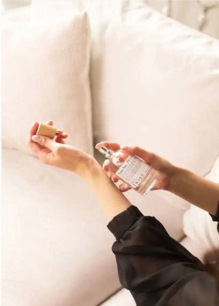 person spraying perfume on wrist
