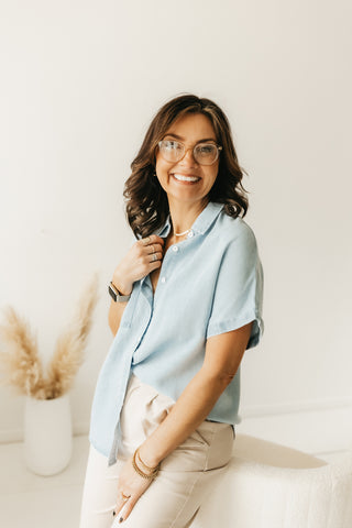 Woman in short sleeve tencel button down shirt and beige trousers