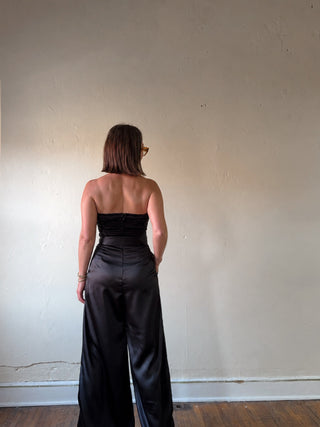 Black strapless satin wide-leg jumpsuit by Flying Tomato, featuring a sleek fit and elegant design, shown on a model.