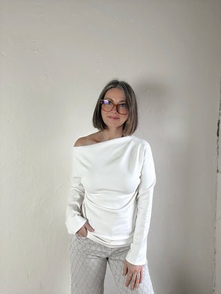 Cream asymmetrical knit top from STEVIE JANE's Contour Drape LSKT collection, featuring a stylish, draped design.
