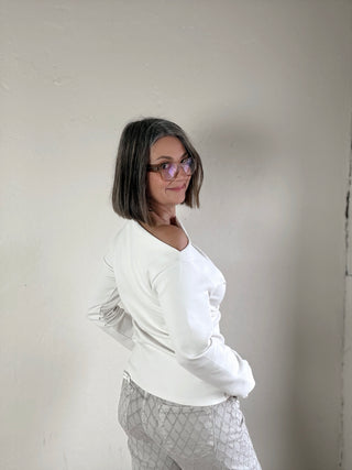 Cream asymmetrical knit top from Stevie Jane's Contour Drape LSKT collection, featuring a stylish, flowing design.