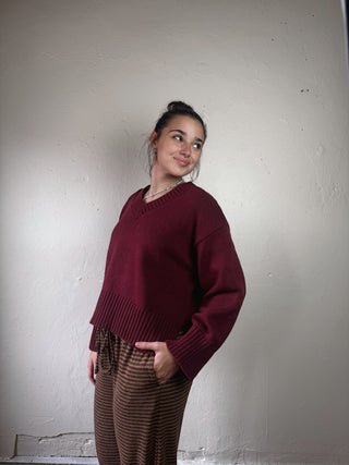 Bordeaux MOD REF weekend V-neck sweater on a hanger with soft knit texture and ribbed collar, front view.