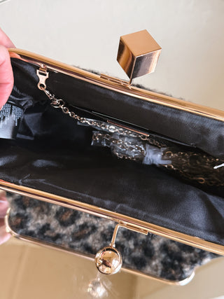 Urban Expressions Aurelia Leopard Boucle clutch bag with a textured leopard print and compact design for stylish carry.
