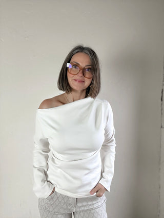 Cream Contour Drape Asymmetrical Knit Top by STEVIE JANE, featuring a stylish draped design and asymmetrical hem.