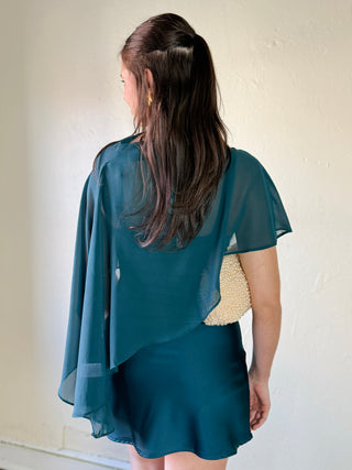 LE LIS satin slip dress with a cape overlay, elegant and flowy, featuring smooth fabric and stylish design.