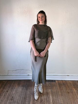 SUNDAY EDITION BY LE LIS boat neck cape slip midi dress with flowing fabric and elegant design, shown on a hanger.