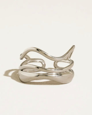 Silver abstract ring featuring modern design from the FLÂNERIE BY MAIQ Sloane collection, displayed on a neutral background.