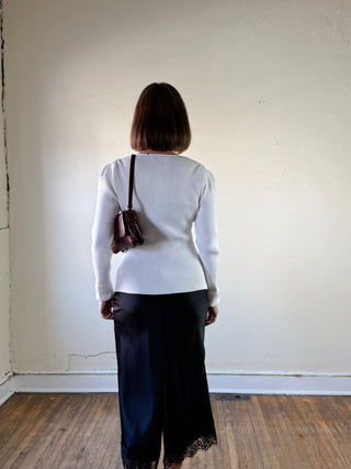 Off-white fitted ribbed button cardigan by MABLE, featuring a close-up of the textured knit fabric and button details.