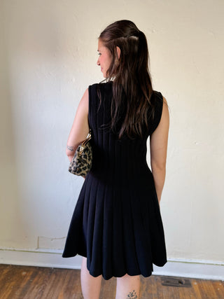 SHE + SKY DMIN sleeveless flare sweater dress in soft knit fabric, shown on a hanger with a neutral background.