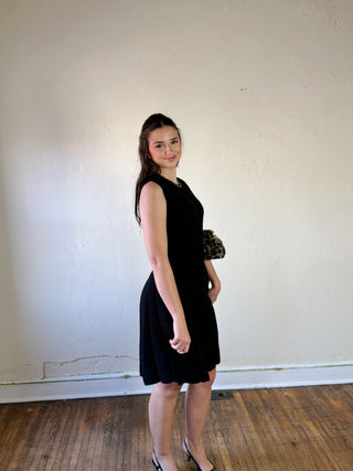 SHE + SKY DMIN sleeveless flare sweater dress in soft knit fabric, styled with a high neckline and fitted waist.