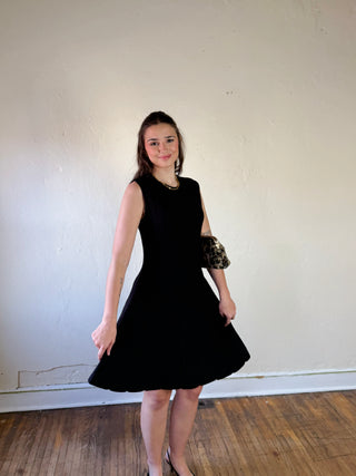 SHE + SKY DMIN sleeveless flare sweater dress in soft knit fabric, featuring a fitted bodice and flowing skirt, displayed on a mannequin.