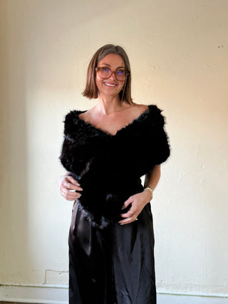Black faux fur capelet shawl by FWJK from FASHION CITY, shown draped over a mannequin with a soft, plush texture.
