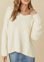 Load image into Gallery viewer, Woman wearing a white fluffy sweater and blue jeans on a beige background
