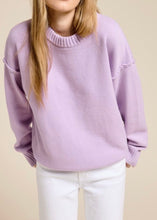 Load image into Gallery viewer, Person wearing a light purple sweater and white pants on a beige background
