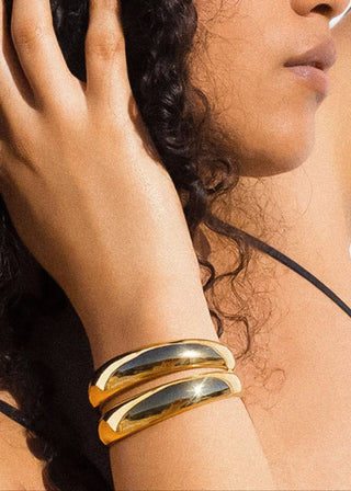 18K layered round bangle bracelet by FLÂNERIE BY MAIQ, featuring sleek gold design and multiple thin circular bands.