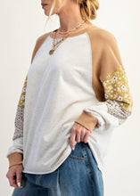 Load image into Gallery viewer, Woman wearing a patchwork sleeve pullover with floral details on a white background
