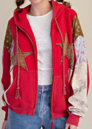 Red hoodie with star designs and floral patterns on a neutral background