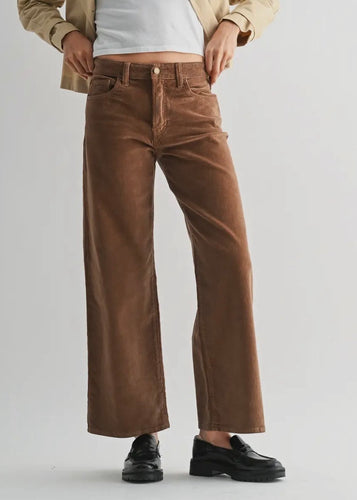Person wearing brown wide-leg pants on a plain background