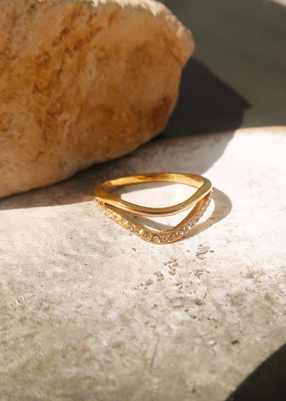 Gold ring with small diamonds on a stone surface