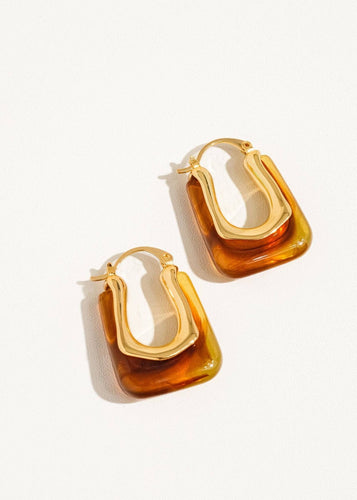 Gold and amber hoop earrings on a white background