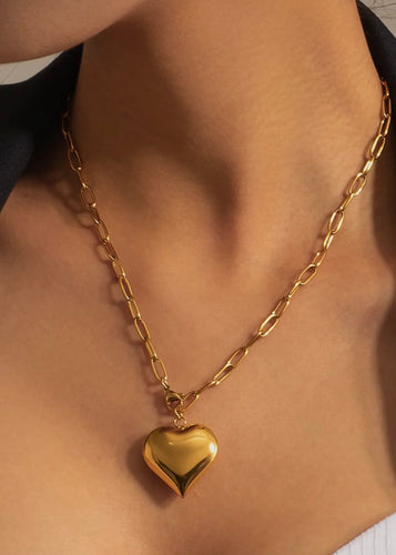 Gold heart-shaped necklace on a person's neck