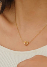 Load image into Gallery viewer, Gold necklace with a heart-shaped clasp worn by a person
