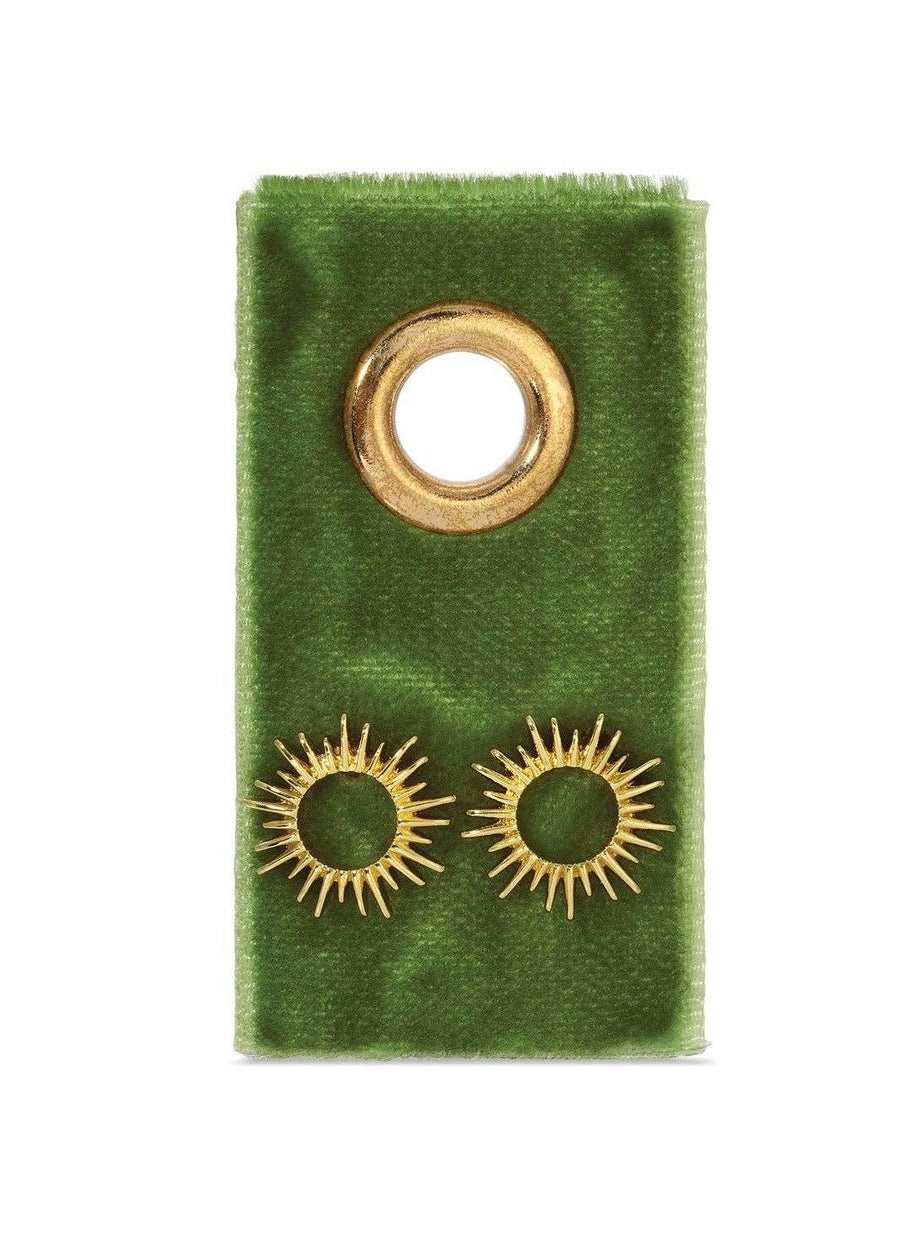 Gold earrings on a green velvet earring card against a white background