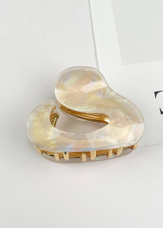 Heart-shaped hair clip with gold accents on a light gray background