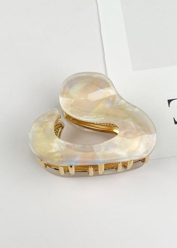 Heart-shaped hair clip with gold accents on a light gray background