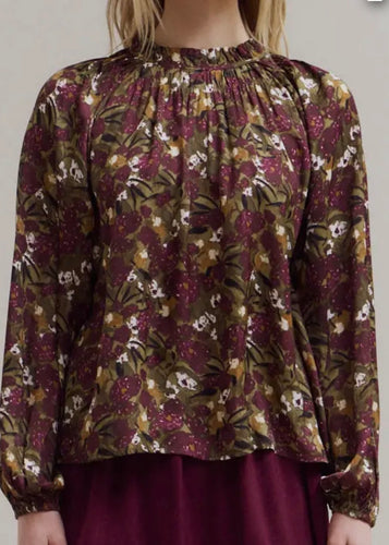 Floral patterned blouse with long sleeves on a plain background