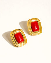 Load image into Gallery viewer, Pair of gold earrings with red stones on a white background
