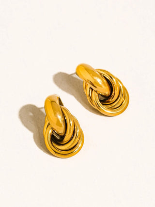 Pair of gold knot earrings on a white background