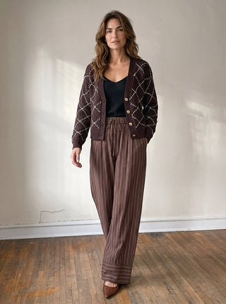 SKIES ARE BLUE whipstitch button cardigan, a cozy knit sweater with buttons and detailed stitching, shown on a model.