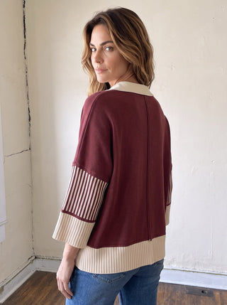 SHE + SKY varsity stripe collar sweater top in cream with navy and red stripes, featuring a ribbed collar and cozy knit fabric.