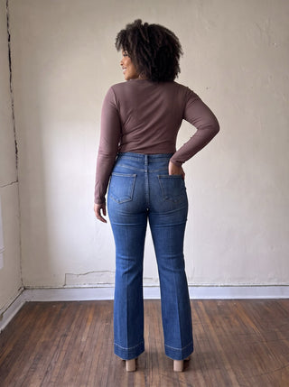 RISEN PBOT extended size comfort sculpt high-rise flare jeans displayed on a model with a natural pose.