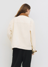 Load image into Gallery viewer, Person wearing a cream sweater and black pants against a white background
