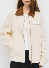 Load image into Gallery viewer, Person wearing a cream jacket with a brown collar on a white background
