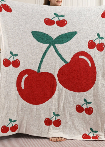 Person holding a blanket with red cherry pattern