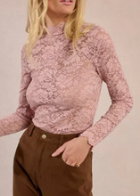 Load image into Gallery viewer, Woman wearing a pink floral blouse and brown pants against a beige background
