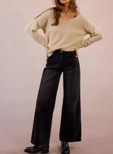 Load image into Gallery viewer, Person wearing a beige sweater and black pants against a plain background
