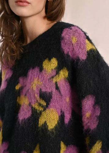 Close-up of a black sweater with purple and yellow floral patterns.