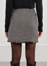 Load image into Gallery viewer, Person wearing a black and white patterned skirt with black knee-high boots on a plain background

