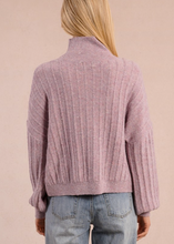 Load image into Gallery viewer, Person wearing a pink ribbed sweater and blue jeans against a beige background
