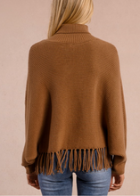 Load image into Gallery viewer, Brown knitted poncho with fringe details on a beige background

