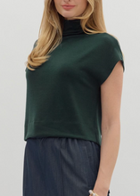 Load image into Gallery viewer, Woman wearing a green top and dark pants on a plain background
